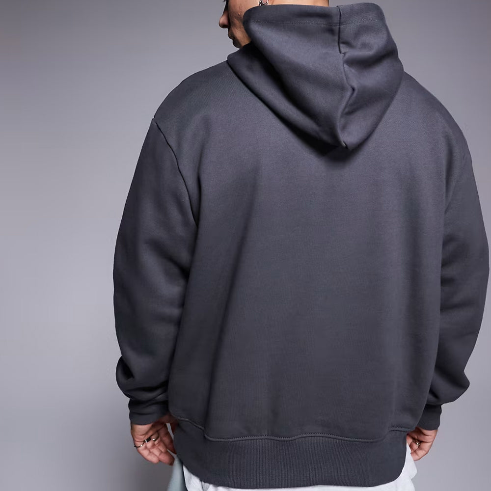 Person wearing a dark gray hoodie against a plain background