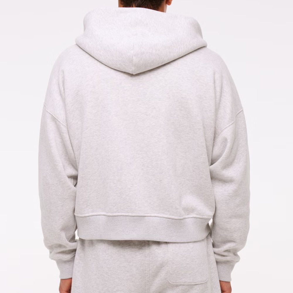 Person wearing a gray hoodie and pants on a white background