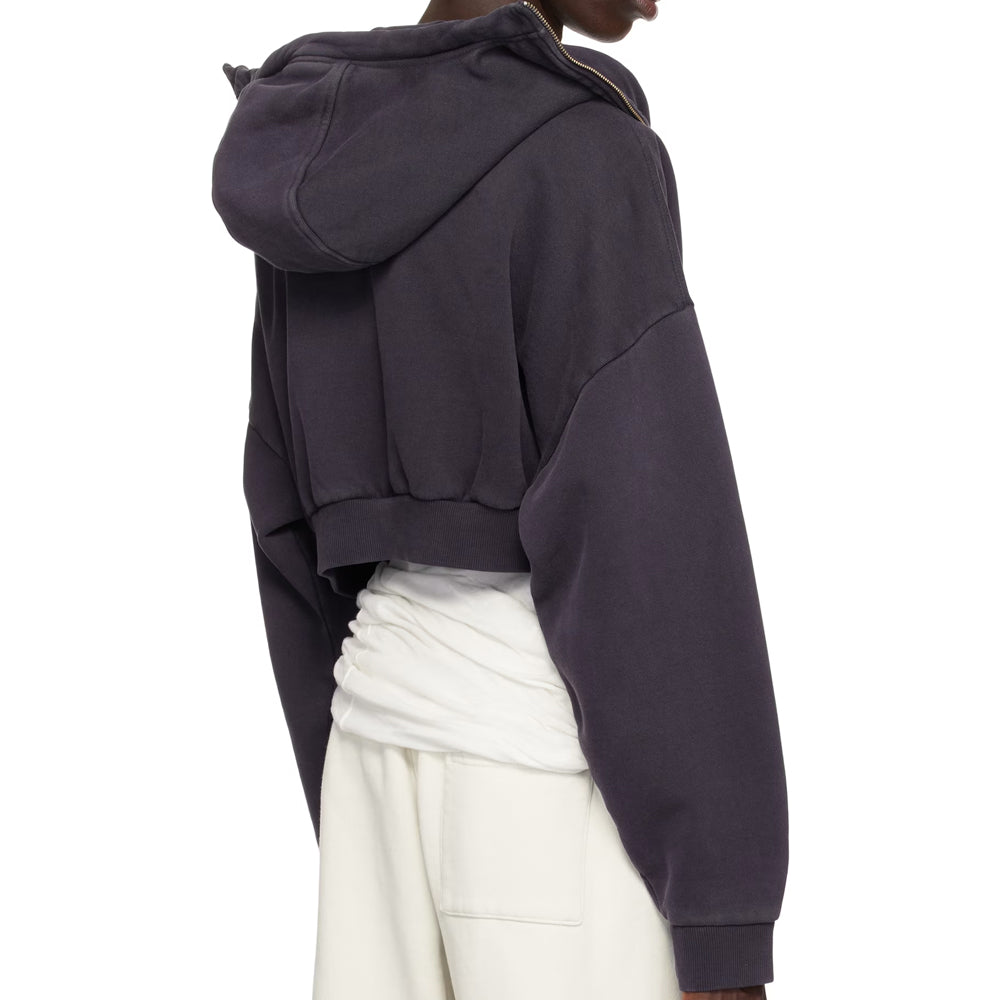 Person wearing a dark gray hoodie and white pants on a white background