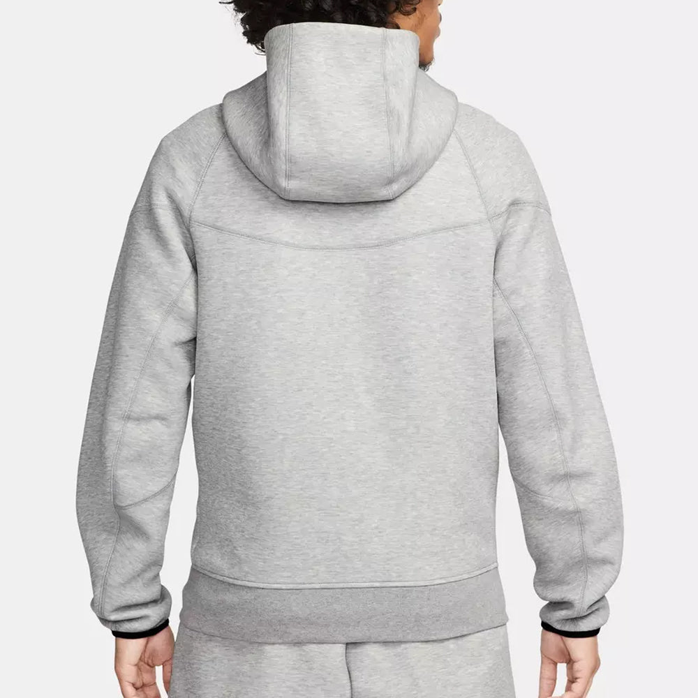 Person wearing a gray hoodie and pants on a white background