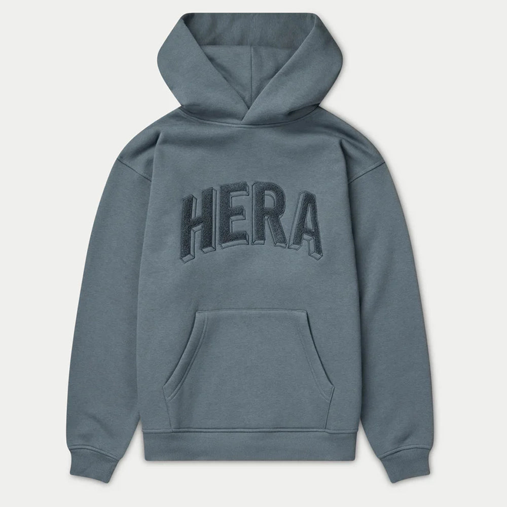 Blue hoodie with 'HERA' branding on the back against a light gray background