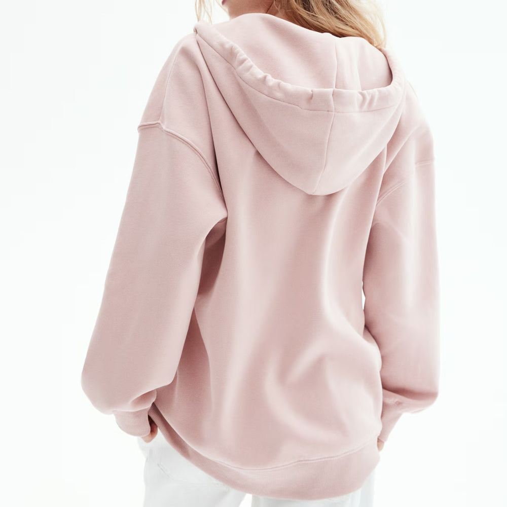 Pink hoodie worn by a person on a white background