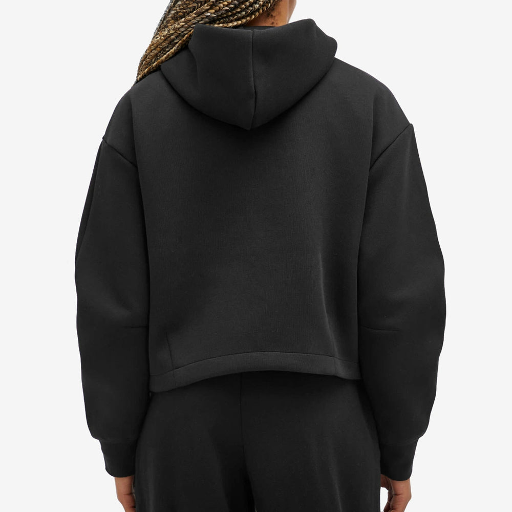 Person wearing a black hoodie from behind on a light gray background