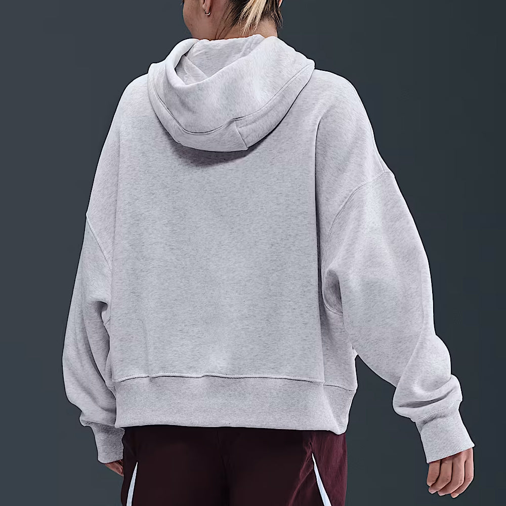 Person wearing a gray hoodie from behind on a dark background