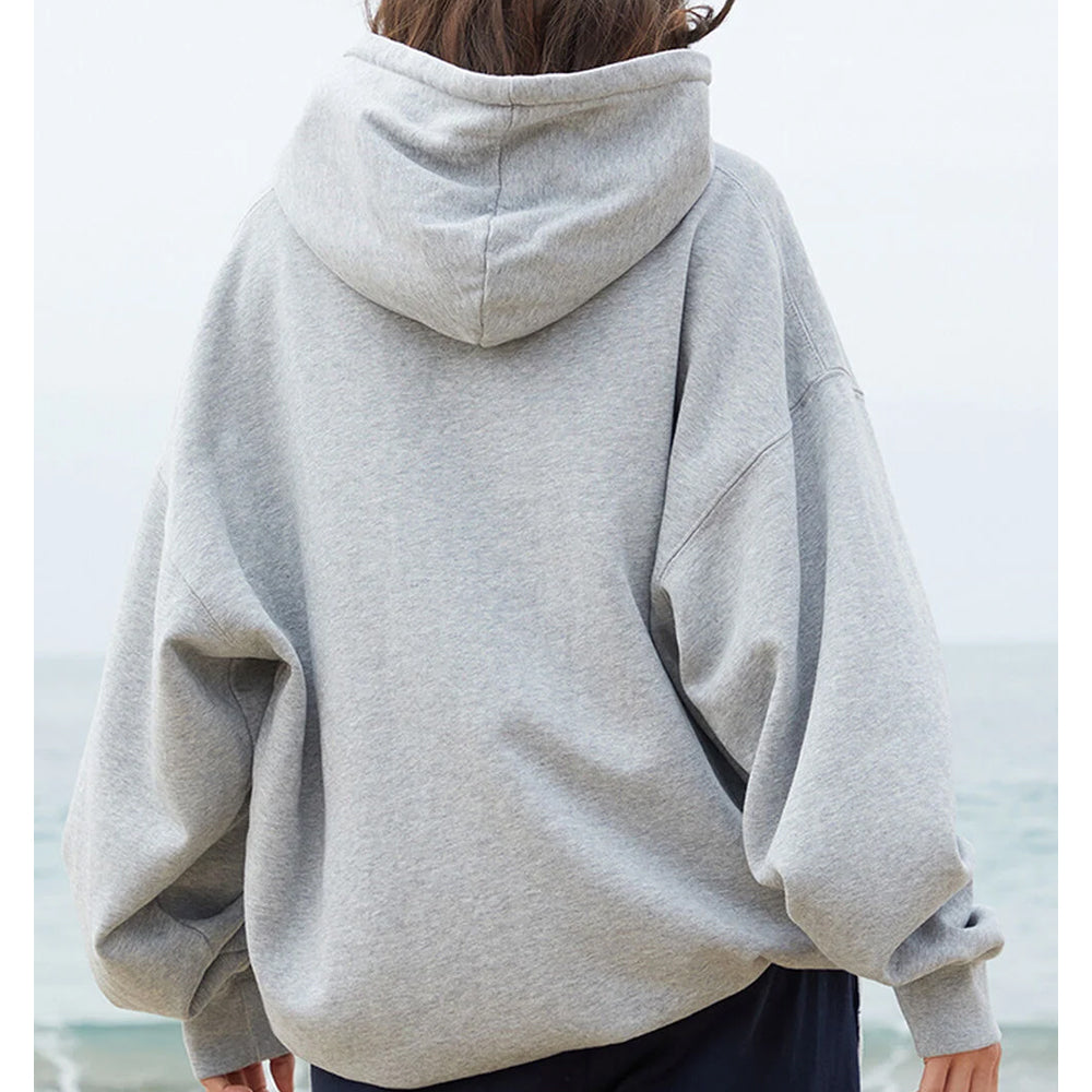 Person wearing a gray hoodie with a blurred background