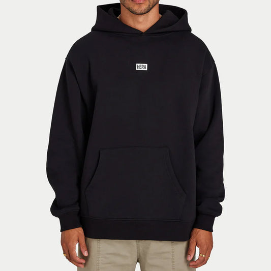 Person wearing a black hoodie with 'HERA' logo on a white background