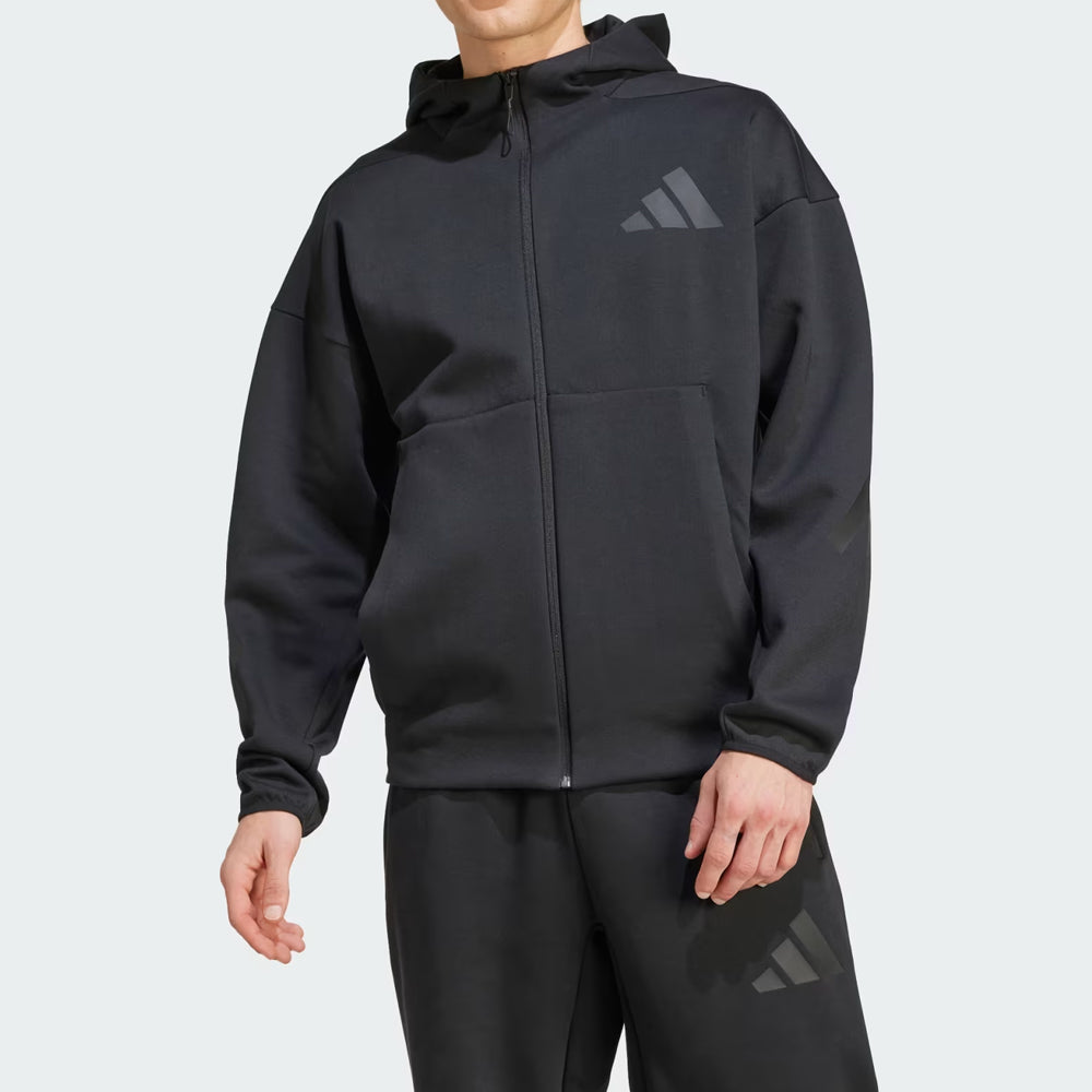 Person wearing a black Adidas hoodie and pants on a light gray background