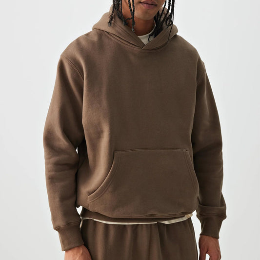 Person wearing a brown hoodie on a white background