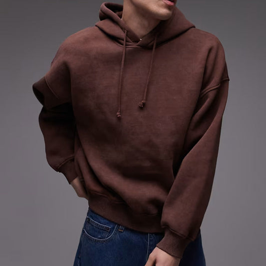 Brown hoodie worn by a person on a gray background