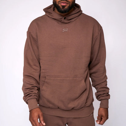 Man wearing a brown hoodie with a logo on a white background
