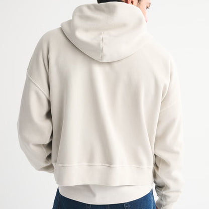 Beige hoodie worn by a person on a white background