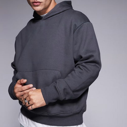 Person wearing a dark gray hoodie against a plain background