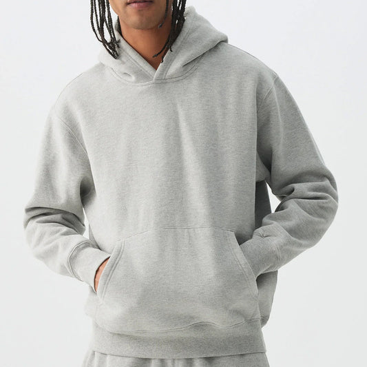 Person wearing a gray hoodie on a plain background