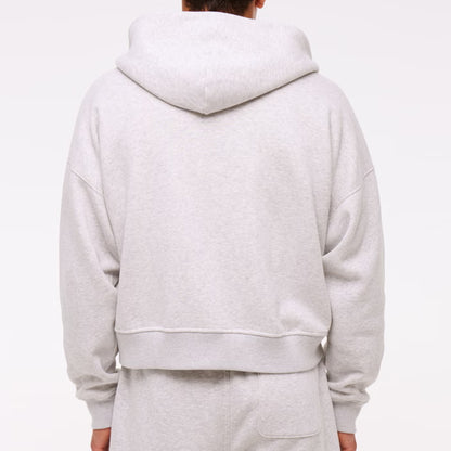 Person wearing a gray hoodie and pants on a white background