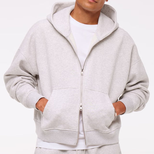 Person wearing a gray hoodie with a white background