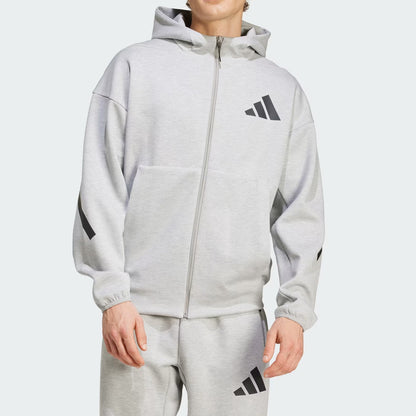 Person wearing a gray Adidas tracksuit on a white background