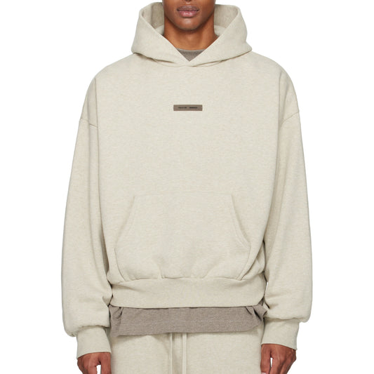 Beige hoodie worn by a person on a white background