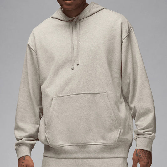 Person wearing a beige hoodie on a gray background