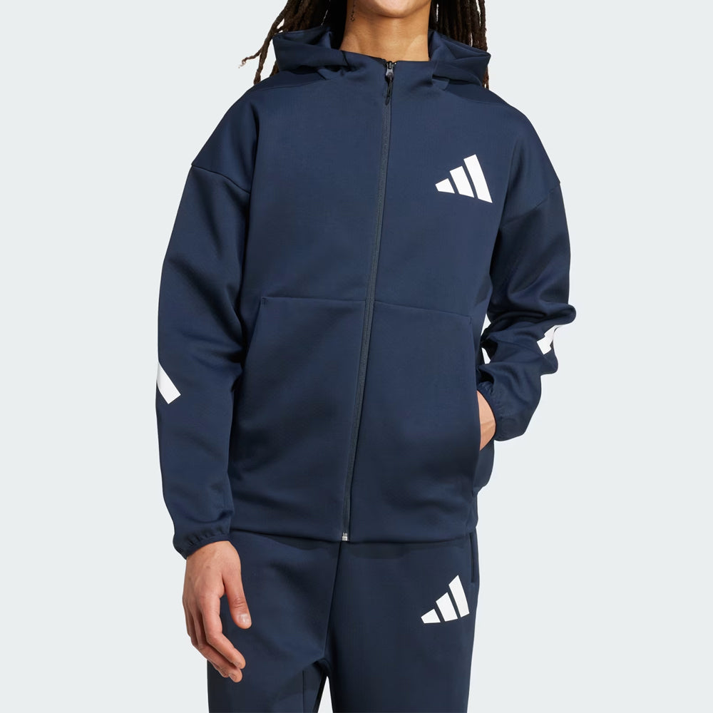 Person wearing a navy blue Adidas tracksuit on a light gray background