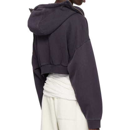 Person wearing a dark gray hoodie and white pants on a white background
