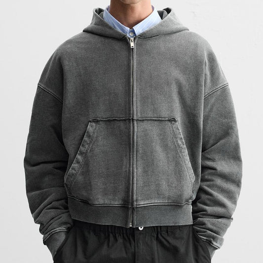 Person wearing a gray hoodie with a zipper on a white background