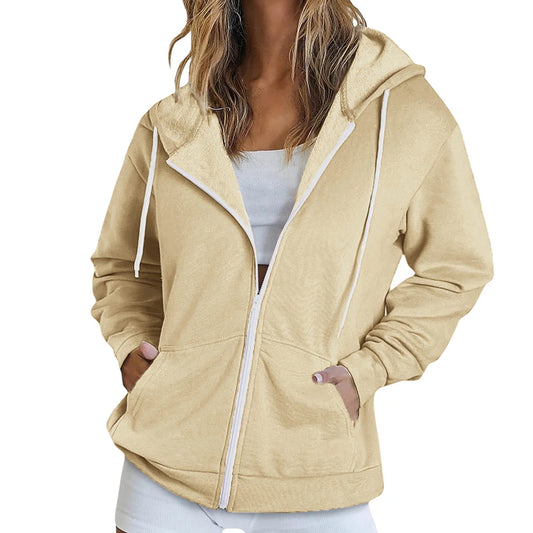 Beige hoodie with white zipper and trim worn by a person on a white background