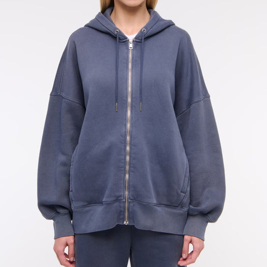 Person wearing a blue hoodie with a zipper on a white background
