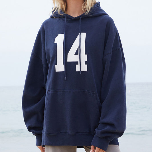 Person wearing a navy blue hoodie with the number 14 on a blurred background