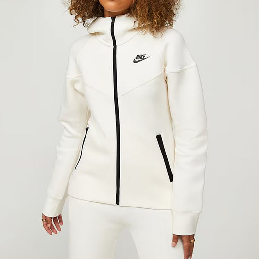Person wearing a white Nike tracksuit on a plain background
