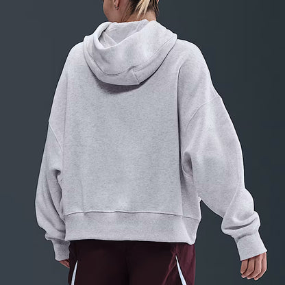 Person wearing a gray hoodie from behind on a dark background