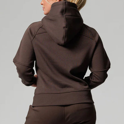 Person wearing a brown hoodie on a gray background